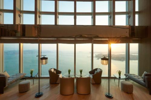 厦门Conrad Xiamen-Free Mini Bar的客房设有带椅子和桌子的大窗户。