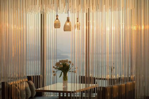 厦门Conrad Xiamen-Free Mini Bar的一间设有桌子和花瓶的用餐室