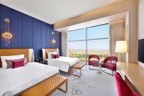 多哈多哈艾雷亚恩古玩系列希尔顿酒店的酒店客房设有两张床和大窗户。