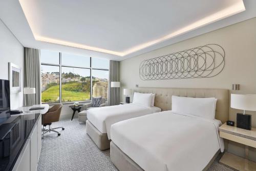 丹吉尔Hilton Tanger City Center的酒店客房设有两张床和电视。
