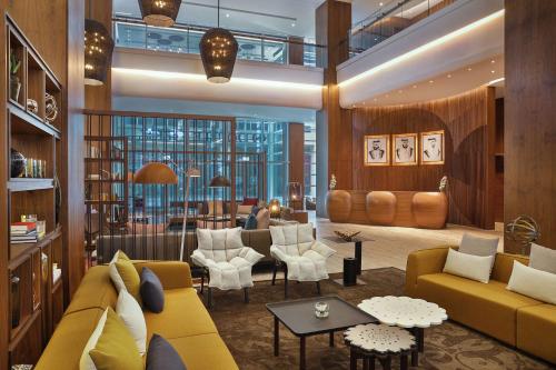 迪拜迪拜希尔顿逸林酒店 - 商务湾的客厅配有黄色的沙发和椅子