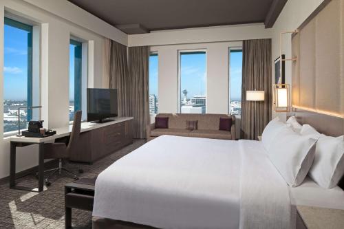 洛杉矶洛杉矶H酒店，希尔顿格芮精选酒店的一间卧室配有一张床和一张书桌及电视
