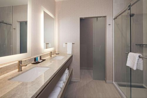洛杉矶洛杉矶H酒店，希尔顿格芮精选酒店的一间带两个盥洗盆和淋浴的浴室