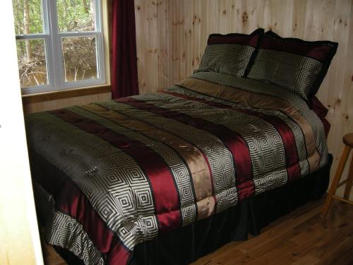 泰道沙克诺伊赛提尔度假屋的一间卧室配有一张带床罩的床和窗户