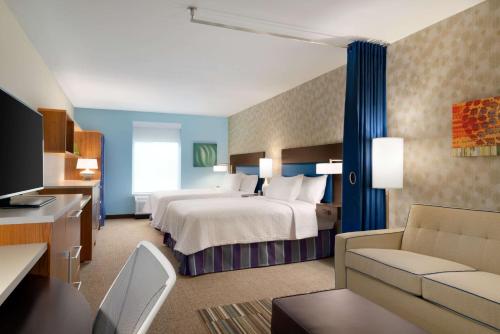 乔利埃特乔利埃特普兰菲尔德希尔顿欣庭套房酒店的酒店客房,配有床和沙发