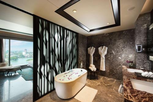 班加罗尔班加罗尔康莱德酒店的带浴缸和盥洗盆的浴室