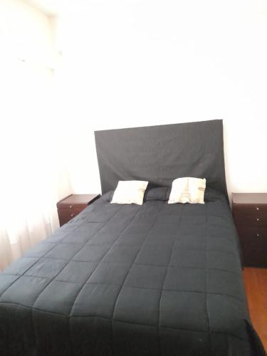 布宜诺斯艾利斯Barracas Charme的一张黑色大床,配有两个枕头