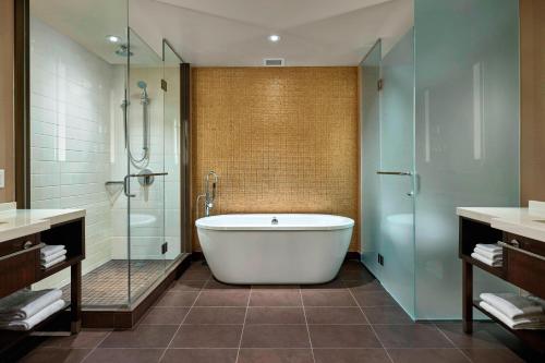 卡尔加里卡尔加里机场航站楼万豪酒店的带浴缸和玻璃淋浴间的浴室。