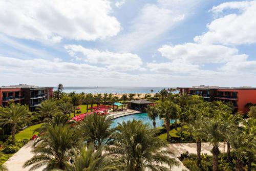圣玛丽亚佛得角凯博萨尔希尔顿酒店 的享有带游泳池和海洋的度假村的空中景致