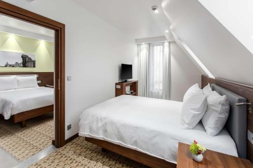 格但斯克Hampton By Hilton Gdansk Oliwa的酒店客房,设有两张床和镜子