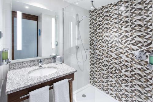 格但斯克Hampton By Hilton Gdansk Oliwa的一间带水槽和淋浴的浴室
