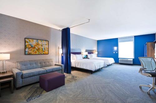 普莱诺Home2 Suites By Hilton Plano Richardson的酒店客房,配有床和沙发