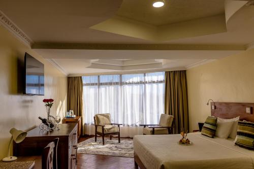 纳纽基The Glacier Hotel Nanyuki的酒店客房设有床和窗户。
