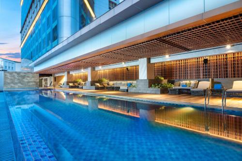 泗水DoubleTree by Hilton Surabaya的一座带椅子的游泳池以及一座建筑