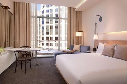 华盛顿Conrad Washington DC的酒店客房设有一张大床和一张桌子。