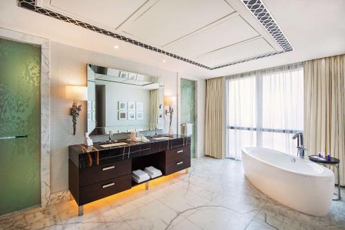 迪拜迪拜希尔顿艾尔哈布图尔城酒店的一间带大浴缸和大镜子的浴室