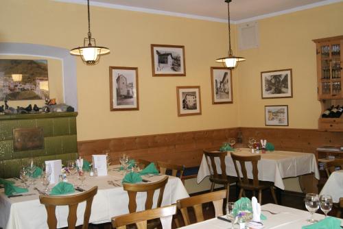 Vicosoprano阿尔伯格皮兹坎酒店的一间设有白色桌椅的用餐室