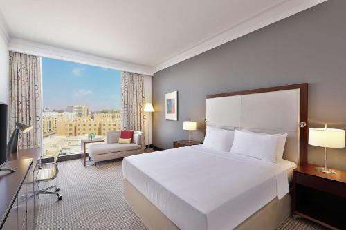 多哈Doubletree By Hilton Doha - Al Sadd的卧室设有一张白色大床和一扇窗户。