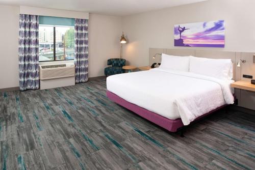 林伍德Hilton Garden Inn Seattle Lynnwood, Wa的酒店客房设有床和窗户。