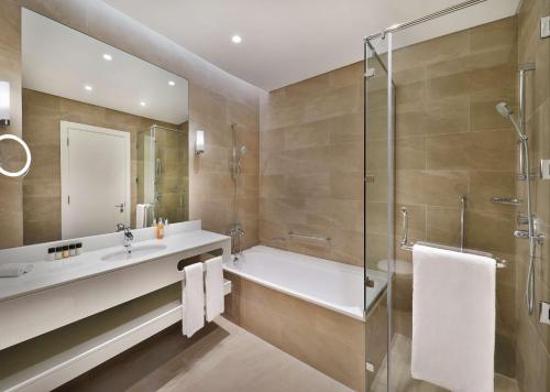 多哈Aleph Doha Residences, Curio Collection By Hilton的带浴缸、水槽和淋浴的浴室