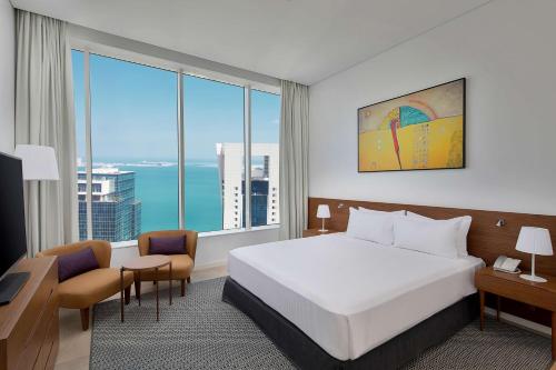 多哈Aleph Doha Residences, Curio Collection By Hilton的酒店客房设有一张床和一个大窗户