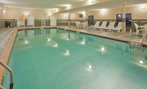 圣克劳德圣克劳德希尔顿恒庭旅馆及套房酒店的酒店设有一个大型游泳池,配有椅子