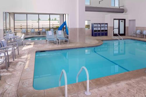 马尔伯勒马尔堡希尔顿合博套房酒店的酒店的大型游泳池配有桌椅