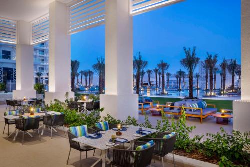 阿布扎比Hilton Abu Dhabi Yas Island的度假酒店的天井配有桌椅