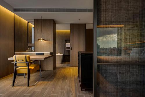 台北台北时代寓所-希尔顿启缤精选酒店的厨房配有桌子和黄色椅子
