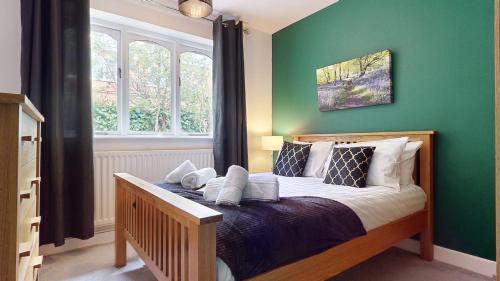欣克利Charming 3 Bed Bungalow Parking & Wifi Business and Leisure by Jesswood Properties的一间卧室配有一张带绿色墙壁的床