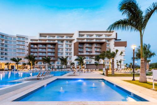 棕榈滩Embassy Suites By Hilton Aruba Resort的大楼前设有游泳池的酒店