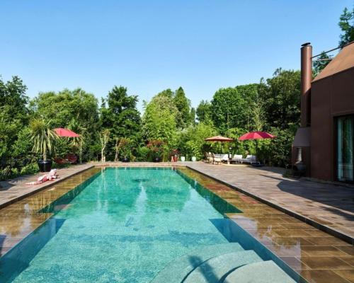 伊维特河畔吉夫Utopia home的一个带蓝色水和红色遮阳伞的游泳池