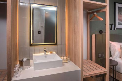 德班Hilton Garden Inn Umhlanga Arch的浴室设有白色水槽和镜子