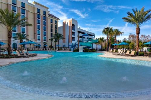 奥兰多Home2 Suites By Hilton Orlando Flamingo Crossings, FL的棕榈树和酒店的游泳池