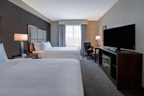 奥兰多Homewood Suites By Hilton Orlando Flamingo Crossings, Fl的酒店客房设有两张床和一台平面电视。