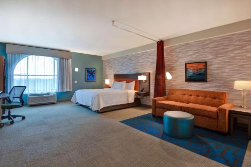 奥兰多Home2 Suites By Hilton Orlando Flamingo Crossings, FL的酒店客房,配有床和沙发