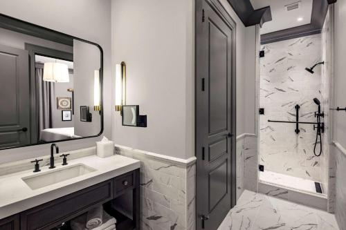 查尔斯顿Hilton Club Liberty Place Charleston的一间带水槽、淋浴和镜子的浴室