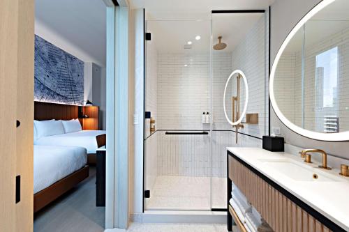 纽约Tempo By Hilton New York Times Square的配有床、淋浴和盥洗盆的浴室