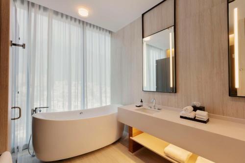 蒙特雷Hilton Monterrey的带浴缸的浴室和大窗户