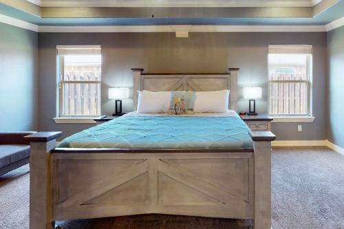 本顿维尔Windsor Retreat的一间卧室配有一张大型木床和两个窗户