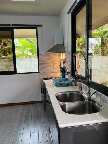 波拉波拉Villa Toa Pearl Bora Bora的带水槽的厨房和2扇窗户