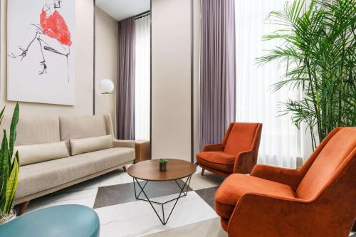 纽约DoubleTree by Hilton Hotel New York City - Chelsea的客厅配有沙发、两把椅子和一张桌子