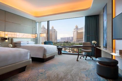 澳门澳门JW万豪酒店的酒店客房设有一张床和一张书桌,享有美景。
