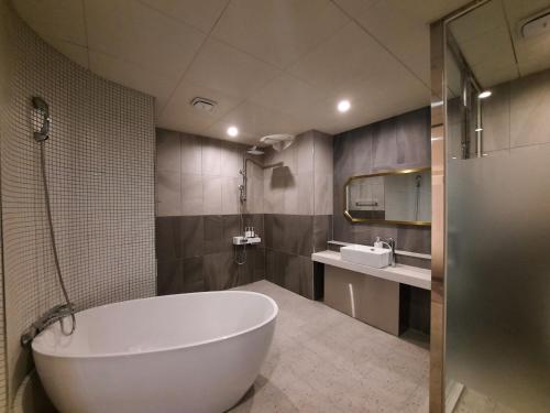 釜山Rein Hotel Busan Yeonsan的一间带大浴缸和水槽的浴室