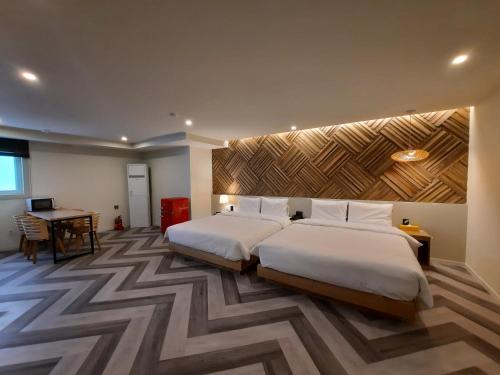 釜山Rein Hotel Busan Yeonsan的酒店客房配有两张床和一张书桌