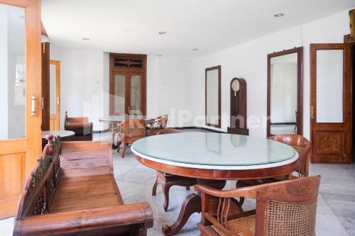 SentoolHotel Limaran 1 Syariah Malioboro Mitra RedDoorz的一间设有玻璃桌和木椅的用餐室