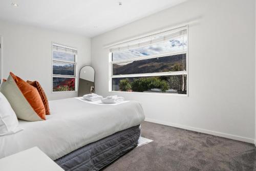皇后镇Whakata on McBride的白色卧室设有一张大床和两个窗户