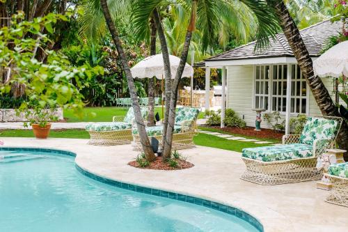 哈勃岛Fig Tree Harbour Island home的房屋旁的游泳池配有椅子和遮阳伞