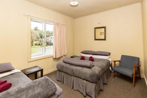 霍基蒂卡卡尼尔宾馆的带三张床、椅子和窗户的房间