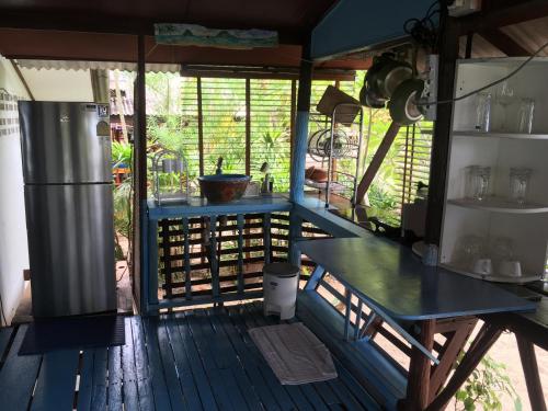 苏梅岛Bangpo Village Tiny Country Beach House的厨房配有桌子和甲板上的冰箱